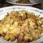 Potatoes with pork and mushrooms in a frying pan